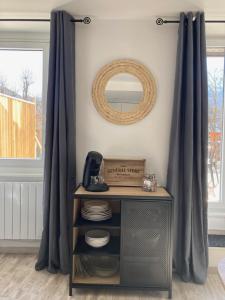 a table with a mirror in a room with curtains at Le Gaudissart 2 in Barcelonnette