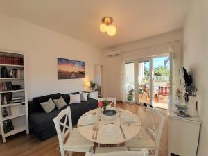 a living room with a table and a couch at Romantic Apartment Anna in the center of Krk in Krk