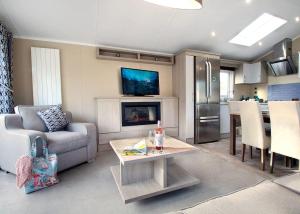 Swanage Coastal Park في سواناج: غرفة معيشة مع أريكة وطاولة ومدفأة