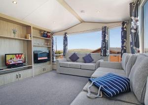 ein Wohnzimmer mit einem Sofa und einem TV in der Unterkunft Swanage Coastal Park in Swanage