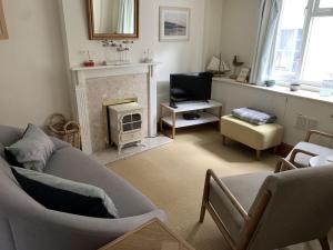 a living room with a couch and a fireplace at Lavender Cottage in Lyme Regis