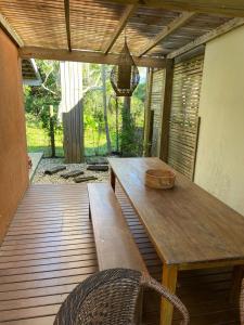 ガロパバにあるCasa da Barrinha Garopabaの木製テーブルとベンチ付きのパティオ