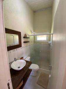 a bathroom with a toilet and a sink and a shower at Morada dos Coqueiros in Garopaba
