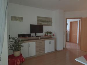 a living room with a desk with a tv on it at Ferienwohnung Ina in Michelau