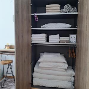 a closet with white towels and a stack of towels at Falling Star Apartman Brzece in Brzeće