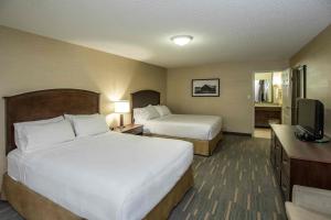 a hotel room with two beds and a television at Holiday Inn Lethbridge, an IHG Hotel in Lethbridge