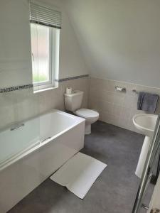 a bathroom with a tub and a toilet and a sink at Recently refurbished 3 bed Villa & superfast wifi in Michaelstow