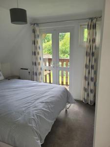 a bedroom with a bed and a window with a balcony at Recently refurbished 3 bed Villa & superfast wifi in Michaelstow