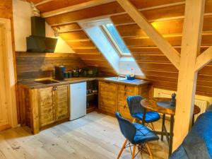 a kitchen with a table and chairs in a cabin at Vantova Chalupa in Ludvíkov