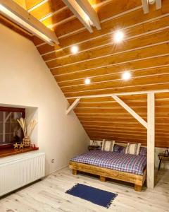 a bed in a room with a wooden ceiling at Vantova Chalupa in Ludvíkov