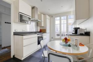 a kitchen with a table with a bowl of fruit on it at Ideal 1 Bd Flat with Balcony - Paris 05 in Paris