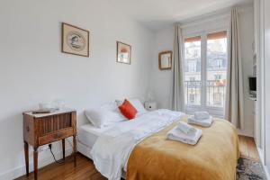 a white bedroom with a bed and a window at Ideal 1 Bd Flat with Balcony - Paris 05 in Paris