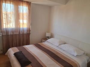 um quarto com uma cama grande e uma janela em Cozy Two-Bedroom Apartment em Zadar