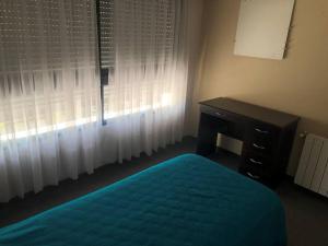 1 dormitorio con cama, escritorio y ventana en Amplio departamento en zona céntrica en Junín