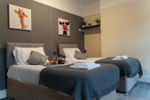 a bedroom with two beds with a tray of food on it at Whitworth House, Sleeps 6 TVs in all bedrooms, WIFI - 3 bedroom in Northampton