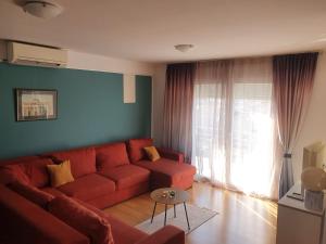 uma sala de estar com um sofá vermelho e uma janela em Cozy Two-Bedroom Apartment em Zadar