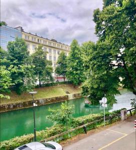a river with a boat in the water next to a building at Apartments Maria in Ljubljana