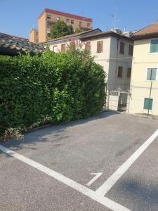 a parking lot with a large bush next to a building at [PIAZZA GARIBALDI] ELEGANTI SUITE CON SAUNA in Udine