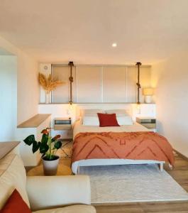 een slaapkamer met een groot bed en een rode deken bij L'ÉCHAPPÉE BRETONNE in Plouider