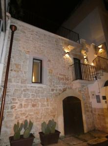 - un bâtiment en pierre avec des cactus en face dans l'établissement NICOLAUS SUITE Wellness Experience, à Bari Palese