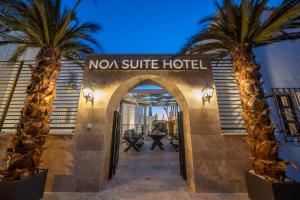 an entrance to a hotel with two palm trees at Noa Suite Hotel Only Adult in Bodrum City