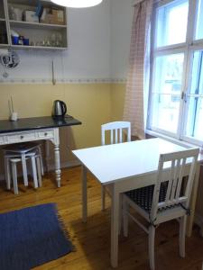 una cocina con mesa y sillas blancas, mesa y ventana en Kodu majutus, en Tallin