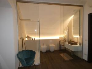 y baño con aseo, lavamanos y silla. en NICOLAUS SUITE Wellness Experience en Bari Palese