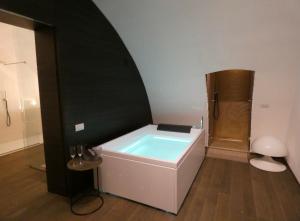 a bath tub in a room with a shower at NICOLAUS SUITE Wellness Experience in Bari Palese