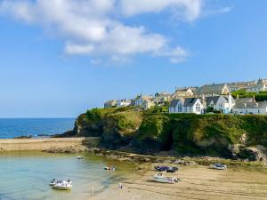 a beach with boats in the water and houses at Sea Thrift in Port Isaac