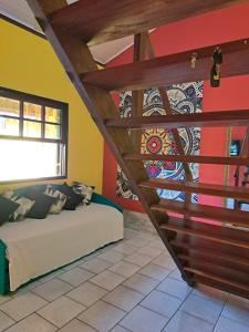 a room with a couch and a staircase with a mural at Casa Amarela in Paraty