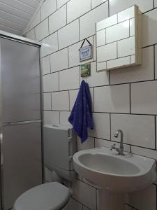 a bathroom with a sink and a toilet and a blue towel at Casa Amarela in Paraty