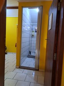 uma casa de banho com um chuveiro e uma porta de vidro em Casa Amarela em Paraty