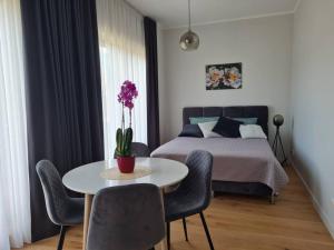 een slaapkamer met een bed en een tafel en stoelen bij Seaside Apartment "Sunrise" with terrace in Ķesterciems, Albatross in Ķesterciems