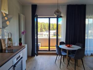 een keuken en eetkamer met een tafel en stoelen bij Seaside Apartment "Sunrise" with terrace in Ķesterciems, Albatross in Ķesterciems
