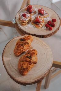 deux assiettes en bois avec des pâtisseries et des fraises sur elles dans l'établissement Sisina Luxury Room Jacuzzi & Piscina, à Portici