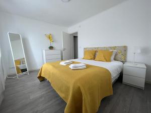 um quarto com uma cama com um cobertor amarelo em Cabriz White House em Sintra