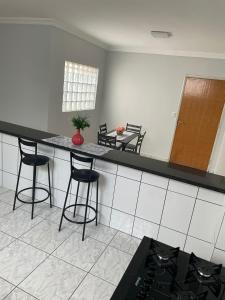 uma cozinha com um balcão e bancos num quarto em Apartamento amplo, confortável e equipado - Apt 101 em Anápolis
