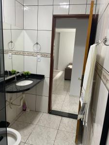 a bathroom with a sink and a toilet at Apartamento amplo, confortável e equipado - Apt 101 in Anápolis