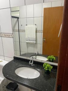 uma casa de banho com um lavatório e um espelho em Apartamento amplo, confortável e equipado - Apt 101 em Anápolis