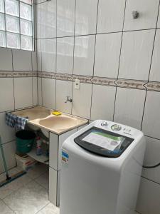 uma máquina de lavar roupa na casa de banho com um lavatório em Apartamento amplo, confortável e equipado - Apt 101 em Anápolis