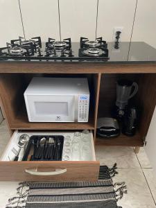 a microwave oven sitting on top of a shelf at Apartamento amplo, confortável e equipado - Apt 101 in Anápolis