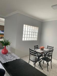 a dining room with a table and chairs and a window at Apartamento amplo, confortável e equipado - Apt 101 in Anápolis