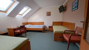 a room with two beds and a table and chairs at Penzion Aida Ostrava in Ostrava