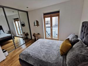 a bedroom with a couch and a large window at Beautiful central townhouse w/ parking for 2 cars in Brighton & Hove