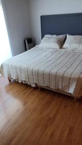 a bed in a bedroom with a wooden floor at TriMar Frente al mar in Playa Unión +12 photos