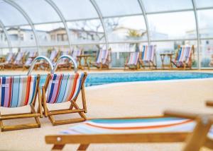 a group of chairs sitting next to a swimming pool at Mersea Island Holiday Park in East Mersea