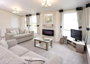 sala de estar con sofá y TV en Mersea Island Holiday Park, en East Mersea