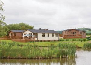 a row of houses next to a river at Wigmore Lakes Lodges in Cardeston