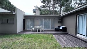 a patio with a table and chairs on a deck at Casa Juno Pinamar Norte in Pinamar