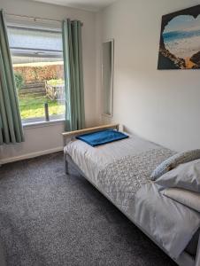 een kleine slaapkamer met een bed en een raam bij Rural Cosy Three Bedroom Cottage in Girvan